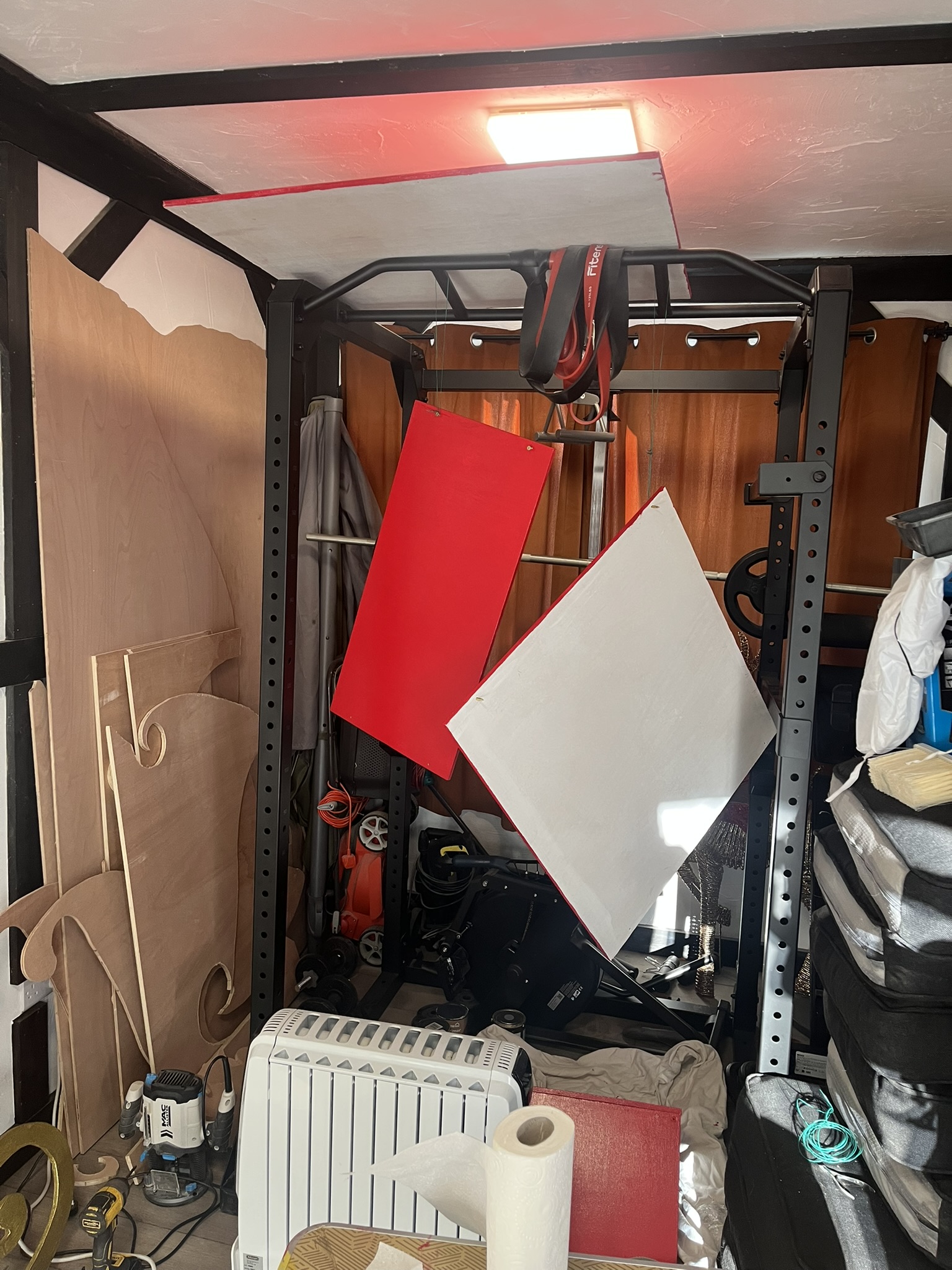 Painted plywood pieces hanging from a power rack