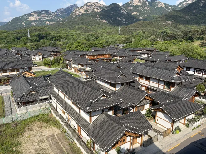 Many traditional Korean houses with mountains in the background