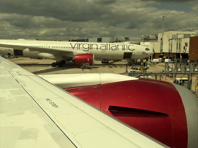 A Virgin Atlantic plane at a gate in Heathrow with red engines