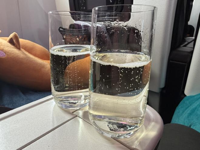 Two tumblers of Prosecco sat on the central arm of aeroplane seats