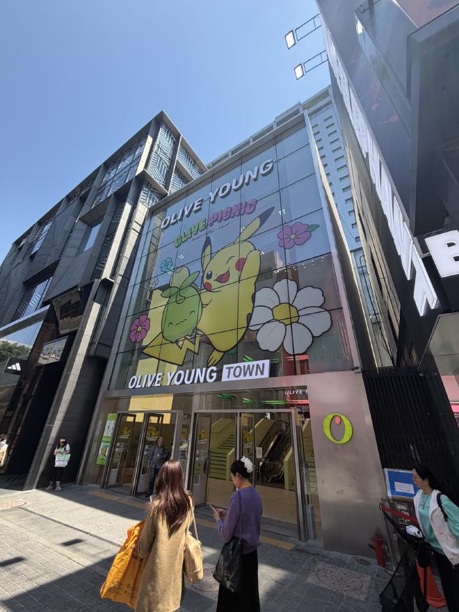 A tall glass building with a decal of Pokémon above the front door