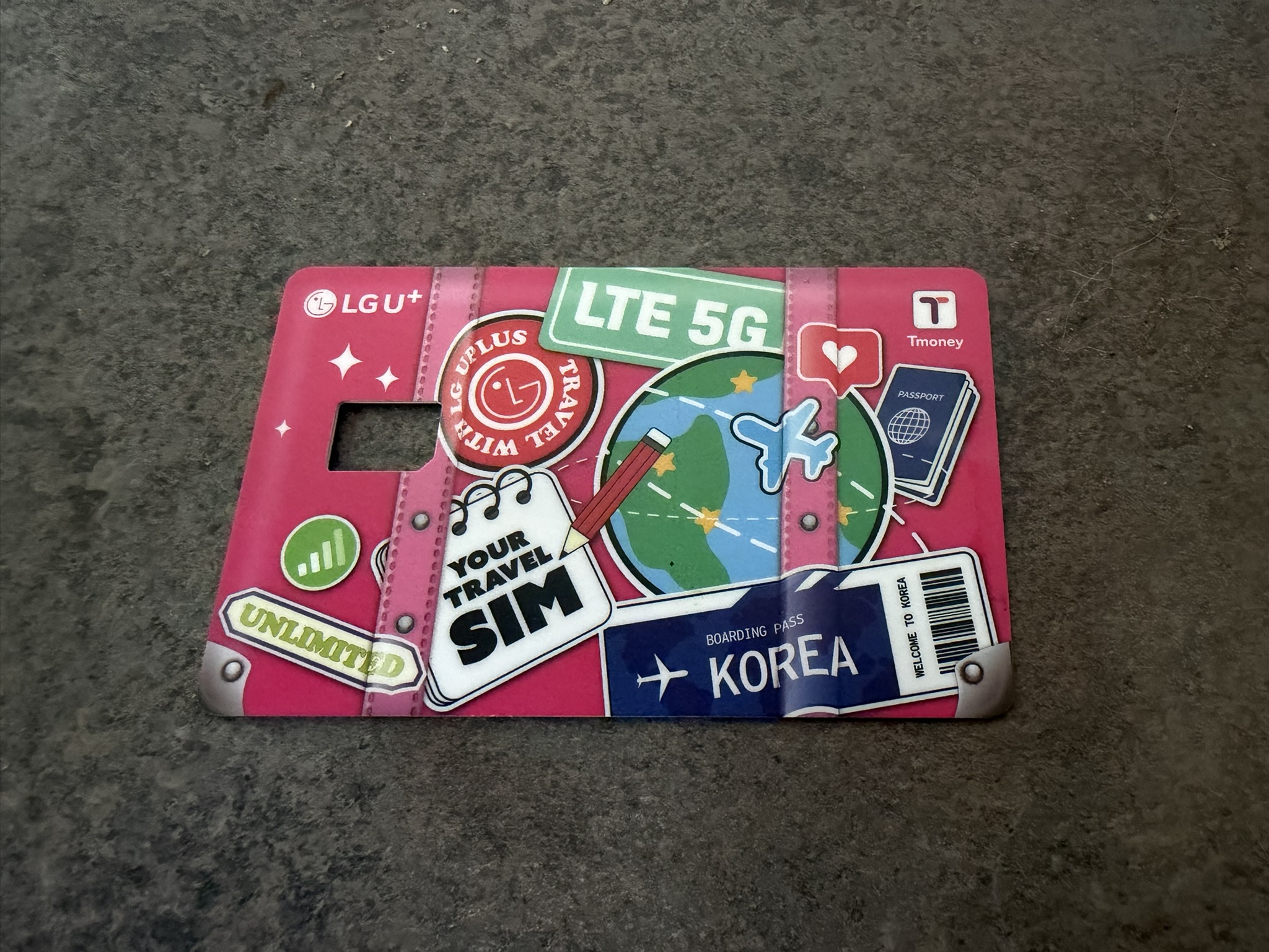 A T-Money Card A pink payment card with a hole for a SIM card in it