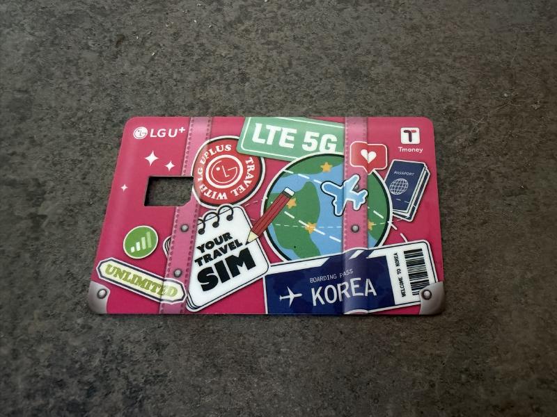 A pink payment card with a hole for a SIM card in it