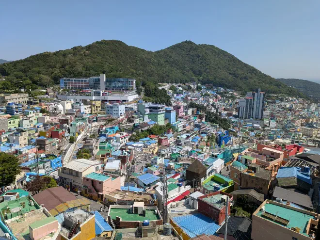 A city filled with different coloured buildings sprawling up a hillside