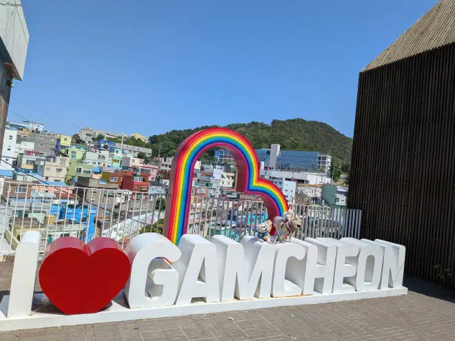A sign saying 'I love Gamecheon' with two small dogs standing atop it