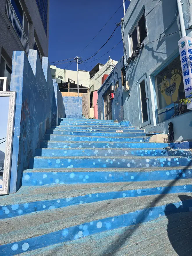 Stone steps painted blue with bubbles lead up to some stone houses