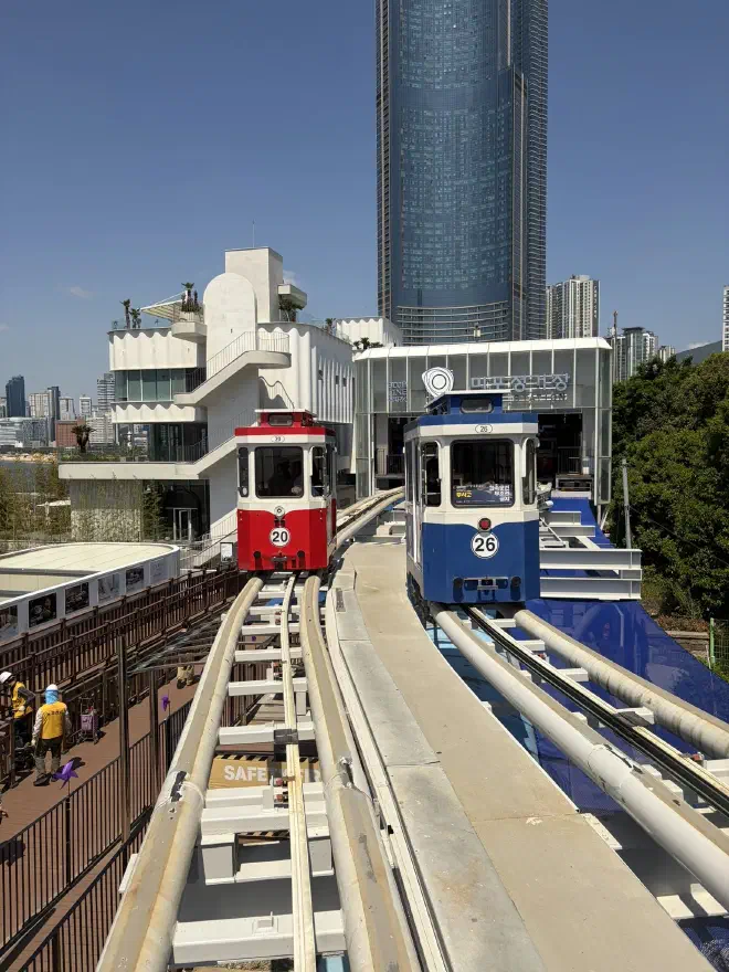 A red and blue cab sit on elevated rails