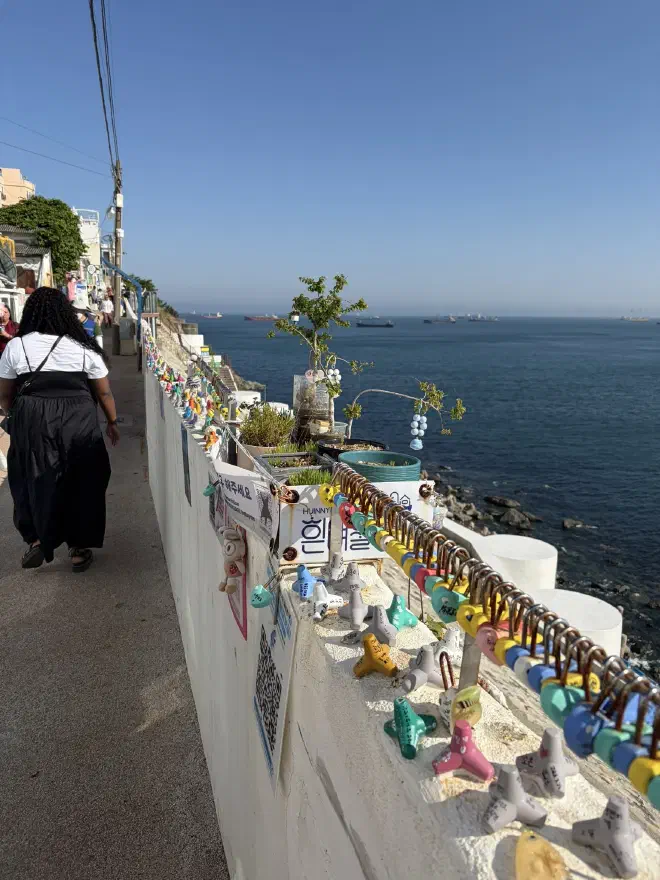 The walk along the sea A wall next to the ocean covered in locks and small painted knick-knacks