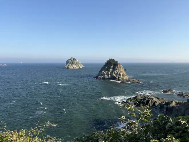 Two rocky islands off the coast in a calm ocean