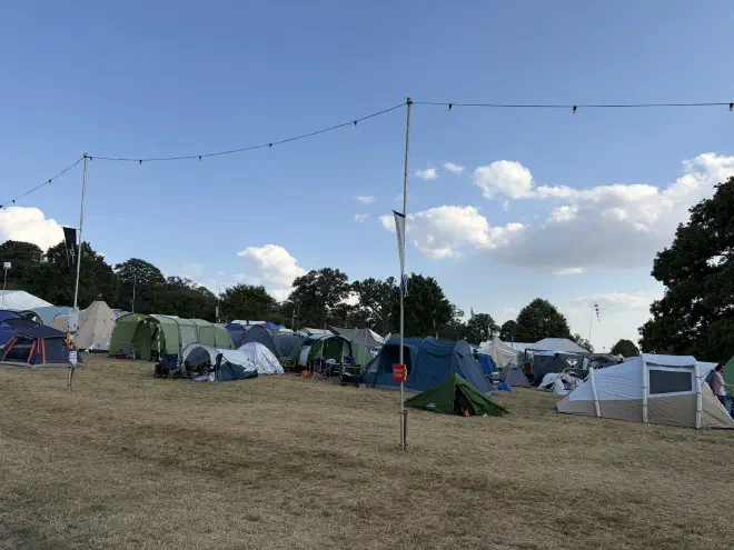 Tents of various sizes sit on dry yellow grass