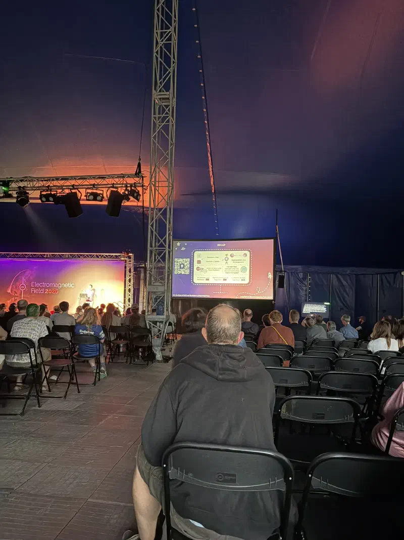 people sit in an auditorium watching a presentation