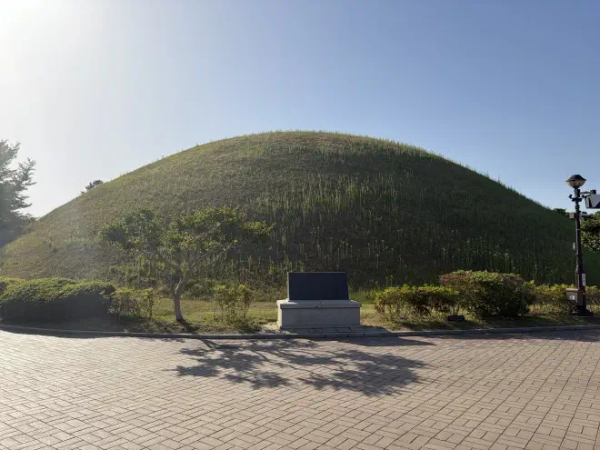 A rounded hill with a sign in front of it
