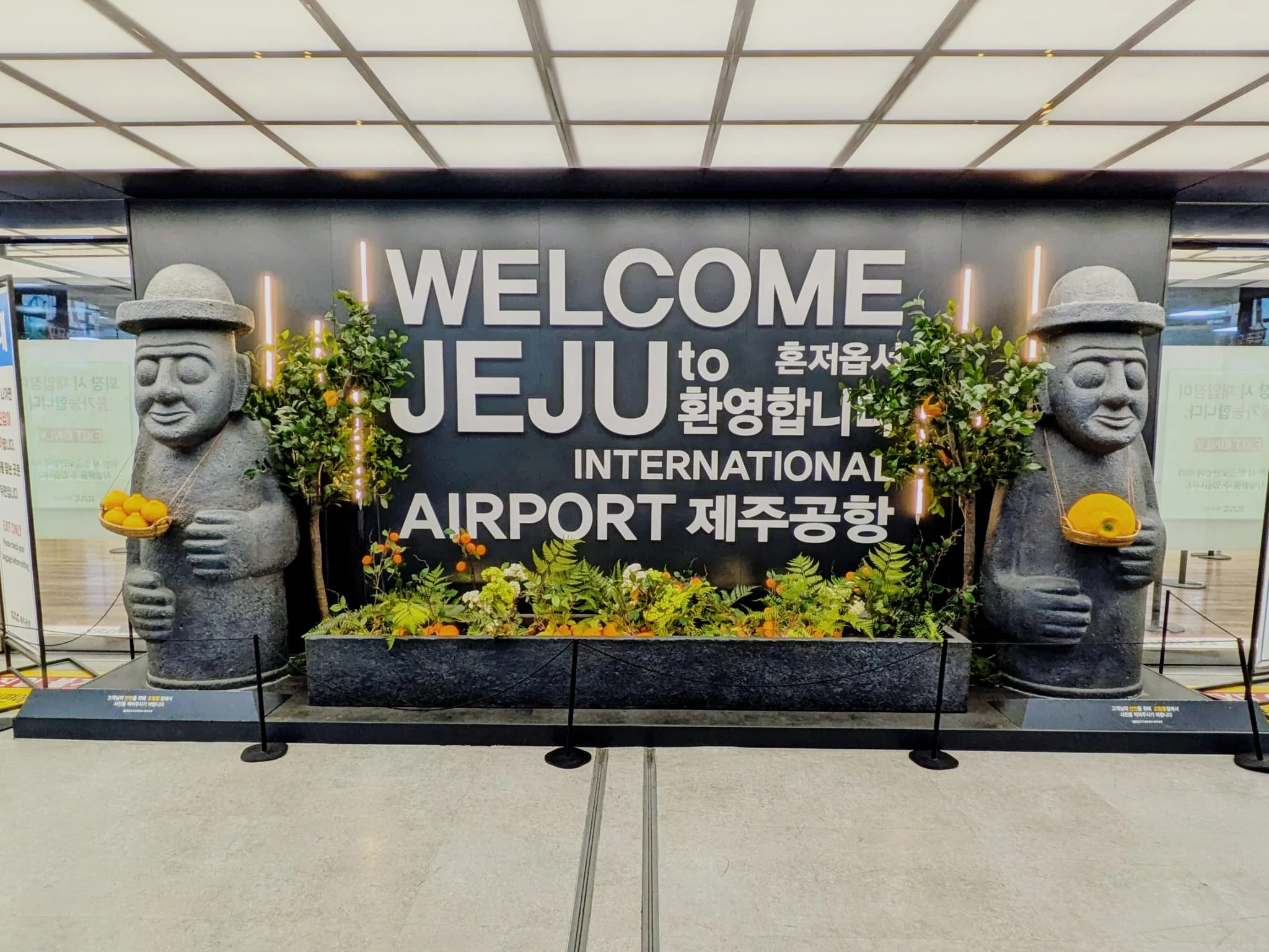 Welcome to Jeju A welcome to Jeju sign with stone statues either side of it