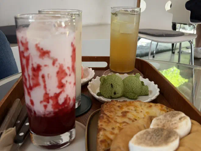 An adorable dessert in the shape of a bear Green matcha-flavored dessert sculpted into the shape of a sleeping bear sits on a plate with other drinks.