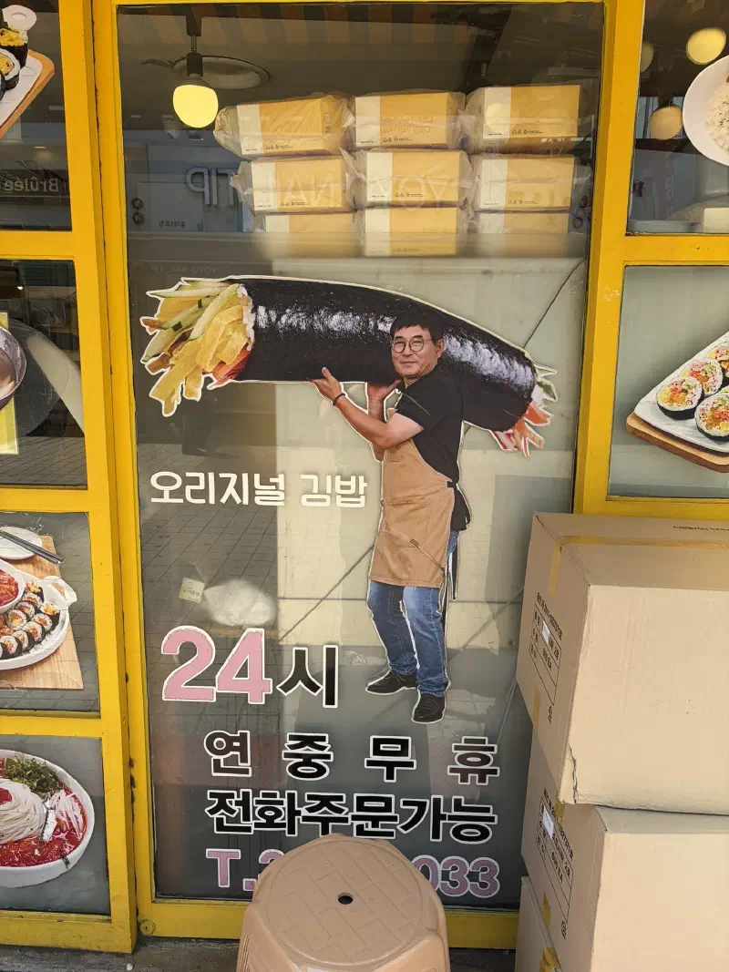 An advertisement of a man in an apron hauling a giant gimbap