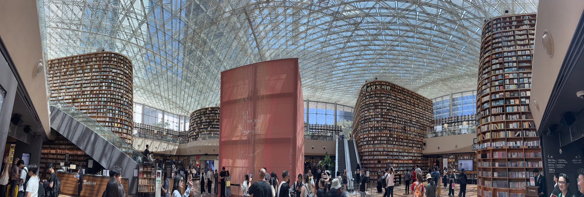 Very tall shelves in a very big library A panoramic picture of a shopping centre with tall walls covered in books