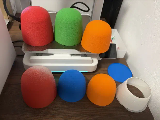 Various coloured plastic gumdrops sat on a table and a 3d printer
